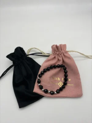 a black and pink pouches with a beaded bracelet