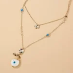 a necklace with a blue eye and a white pendant